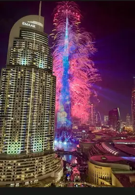 a fireworks display in a city with a tall building at Elegant apartment Dubai downtown in Dubai