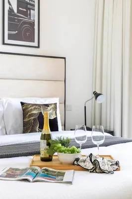 a bedroom with a bed with a table with wine glasses at Frank Porter - Noor 3 Midtown in Dubai