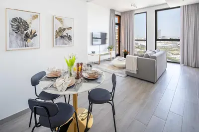 a living room with a table with chairs and a couch at Frank Porter - Noor 3 Midtown in Dubai