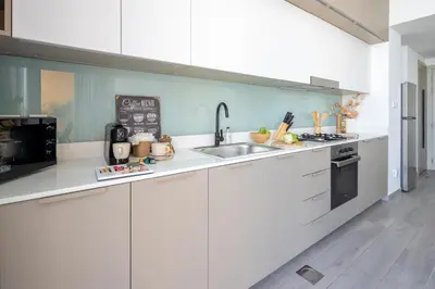 a kitchen with white cabinets and a sink at Frank Porter - Noor 3 Midtown in Dubai
