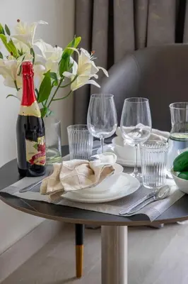 a table with a bottle of wine and glasses on it at Frank Porter - Azizi Riviera 36 in Dubai