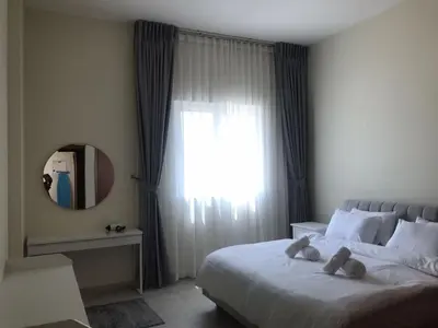 a bedroom with a large bed with a window at Cozy Bedroom Retreat in Green Community Pool View in Dubai