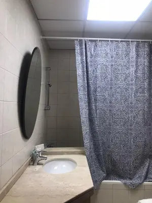 a bathroom with a shower curtain and a sink at Cozy Bedroom Retreat in Green Community Pool View in Dubai