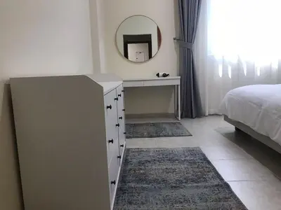a bedroom with a dresser with a mirror and a bed at Cozy Bedroom Retreat in Green Community Pool View in Dubai