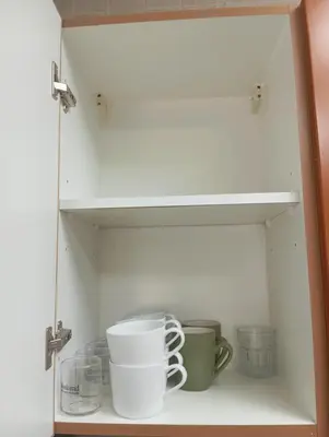 a cupboard with some cups and mugs on it at Cozy Bedroom Retreat in Green Community Pool View in Dubai