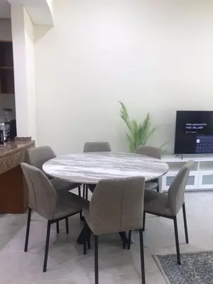 a dining room table with chairs and a tv at Cozy Bedroom Retreat in Green Community Pool View in Dubai