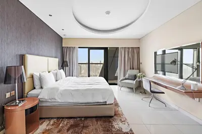 a bedroom with a bed and a desk and a couch at ALiving Luxury 3BR High-Rise I Burj Khalifa View I Paramount Towers, 6101 in Dubai
