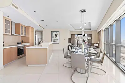 a kitchen and dining room with a table and chairs at ALiving Luxury 3BR High-Rise I Burj Khalifa View I Paramount Towers, 6101 in Dubai