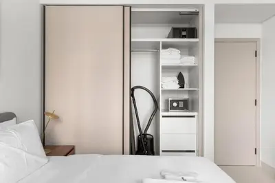 a bedroom with a white bed and a closet at Luxury Stay at Marina Vista, Dubai Harbour in Dubai