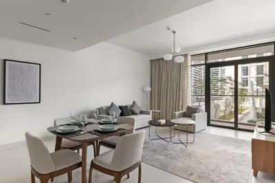 a white living room with a table and chairs at Luxury Stay at Marina Vista, Dubai Harbour in Dubai