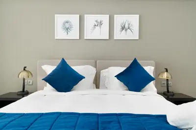 a bedroom with a bed with blue and white pillows at BellaViu Holiday Homes-From City Rush to Calm -2BR Retreat in DAMAC Prive in Dubai