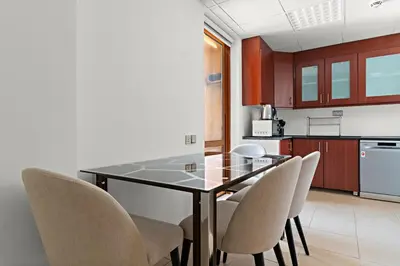 a kitchen with a glass table and chairs at 2-Bedroom Apartment Near To The Beach in Sadaf in Dubai