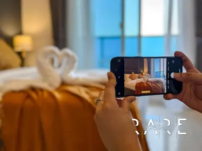a person taking a picture of a pumpkin with a cell phone at Rare Holiday Homes - Near Miracle Garden - Dubai Sports City - Elite Residence - R1108 in Dubai