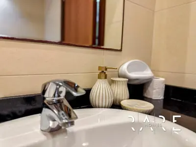 a bathroom sink with a faucet and a mirror at Rare Holiday Homes - Near Miracle Garden - Dubai Sports City - Elite Residence - R1108 in Dubai