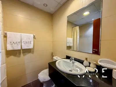 a bathroom with a sink and a mirror at Rare Holiday Homes - Near Miracle Garden - Dubai Sports City - Elite Residence - R1108 in Dubai