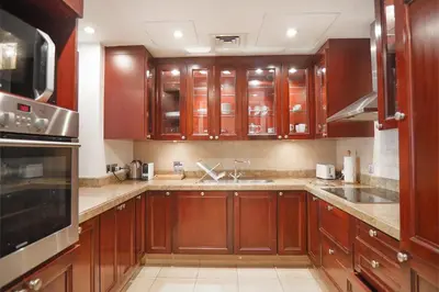 a large kitchen with wooden cabinets and a sink at EasyGo- Spacious, Authentic, City Center in Dubai