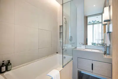 a white bathroom with a tub and a sink at Beachfront Bliss - Marina View - JBR The Address By ĀYA Boutique in Dubai