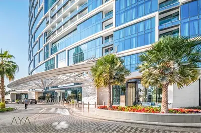 a tall building with palm trees in front of it at Beachfront Bliss - Marina View - JBR The Address By ĀYA Boutique in Dubai