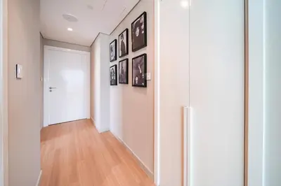 a hallway with a white door and pictures on the wall at PVH - 2BR Artistic Retreat in Downtown Views 2 in Dubai