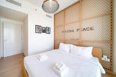 a bedroom with a large bed with two towels on it at PVH - 2BR Artistic Retreat in Downtown Views 2 in Dubai