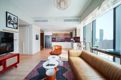 a living room with a couch and a kitchen at PVH - 2BR Artistic Retreat in Downtown Views 2 in Dubai