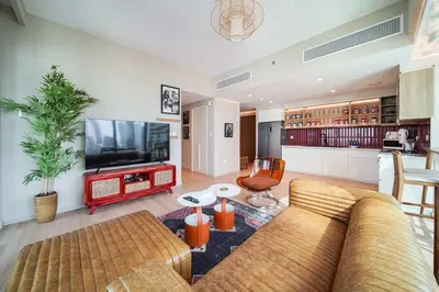 a living room with a couch and a flat screen tv at PVH - 2BR Artistic Retreat in Downtown Views 2 in Dubai