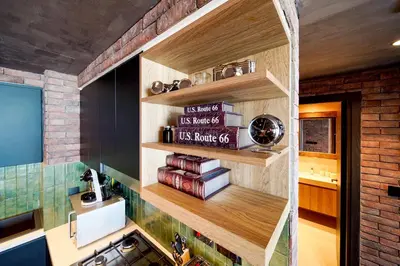 a kitchen with wooden shelves and books on the wall at PVH - Edgy and Modern Comfort 1BR Downtown Views 2 in Dubai