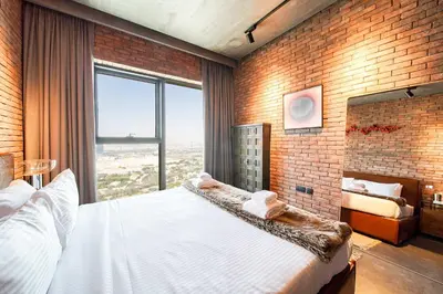 a bedroom with a large white bed and a brick wall at PVH - Edgy and Modern Comfort 1BR Downtown Views 2 in Dubai
