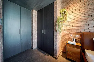 a bathroom with black cabinets and a brick wall at PVH - Edgy and Modern Comfort 1BR Downtown Views 2 in Dubai