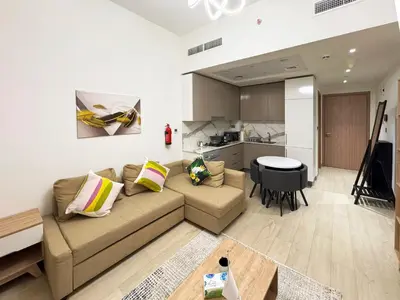 a living room with a couch and a kitchen at Azizi Riviera15 - Meydan by Golden Casa in Dubai