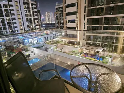 a balcony with a table and a view of a building at Azizi Riviera15 - Meydan by Golden Casa in Dubai