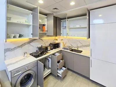 a kitchen with a washing machine and a washer at Azizi Riviera15 - Meydan by Golden Casa in Dubai