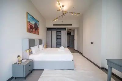 a bedroom with a white bed and a desk at High Floor With Marina View in Dubai