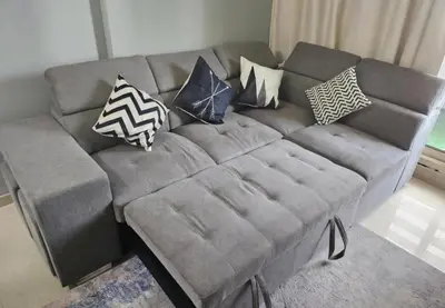 a gray couch with pillows on it in a living room at Royal Residence - Dream tower Marina in Dubai