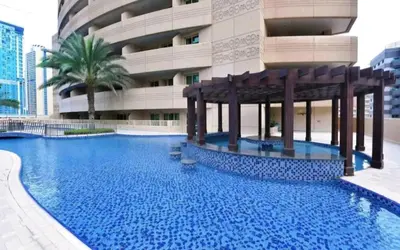 a large swimming pool in front of a building at Royal Residence - Dream tower Marina in Dubai