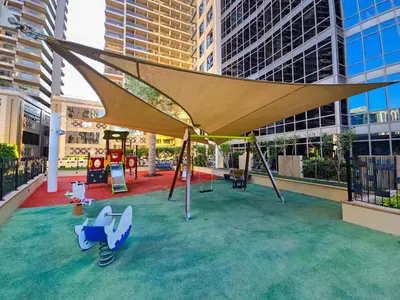 a playground with awning and swings in a city at EasyGo-Signature, City Center, City view in Dubai