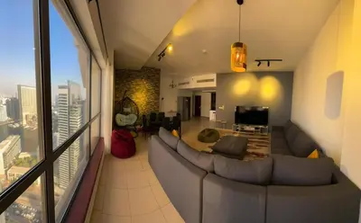 a living room with a large couch and a television at 50 Shades of stay in Dubai