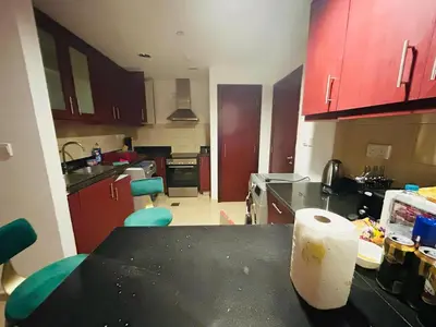 a kitchen with red cabinets and a black counter top at 50 Shades of stay in Dubai