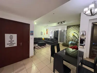a living room with a couch and a dining room at 50 Shades of stay in Dubai