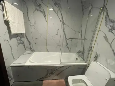 a bathroom with a white tub and a toilet at Nice Studio On Marina Walk in Dubai