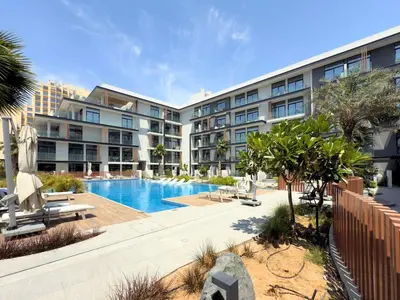 a large apartment building with a swimming pool at Elegant and Cozy Studio Apartment - Amenities Access in Dubai