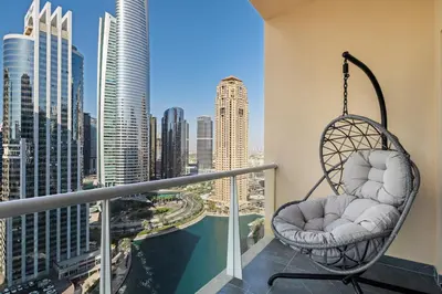 a swing on a balcony with a view of the city at Luxury JLT 1BR Lakeview 5 min Metro & Marina in Dubai