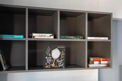 a book shelf with books and a mirror on it at Luxury JLT 1BR Lakeview 5 min Metro & Marina in Dubai