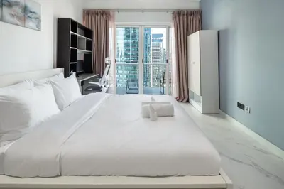 a large white bed in a room with a window at Luxury JLT 1BR Lakeview 5 min Metro & Marina in Dubai