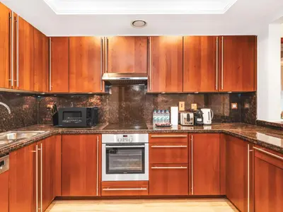 a kitchen with wooden cabinets and stainless steel appliances at Palm Jumeirah Beach Paradise at Fairmont Residence in Dubai