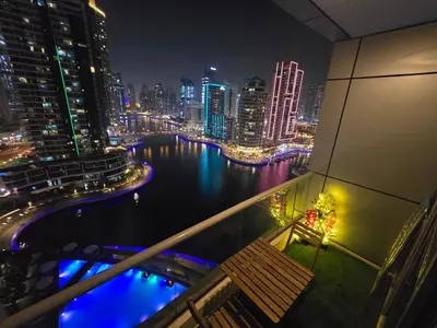 a view of a city at night from a balcony at Dubai Marina Amazing 1BR with Promenade view and Pool view --- Next to JBR beach---Opp JBR tram station in Dubai