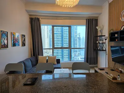 a living room with a blue couch and a large window at Dubai Marina Amazing 1BR with Promenade view and Pool view --- Next to JBR beach---Opp JBR tram station in Dubai