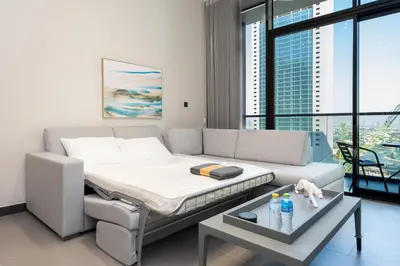 a bed in a room with a couch and a table at Brand New Luxury One Bedroom in Dubai