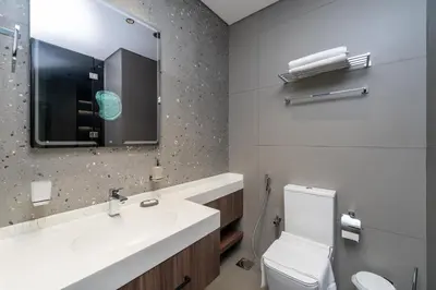 a bathroom with a sink and a toilet and a mirror at Brand New Luxury One Bedroom in Dubai