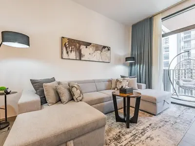 a living room with a couch and a table at Modern & Luxury 1BR -Pool View - Kensington Waters in Dubai